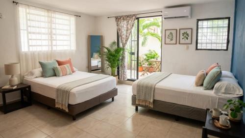 a bedroom with two beds and a balcony at Residencia COCO 28 con Piscina Downtown Cancun in Cancún