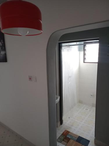 a hallway with a door to a bathroom with a window at TN Apartments Adina in Diani Beach