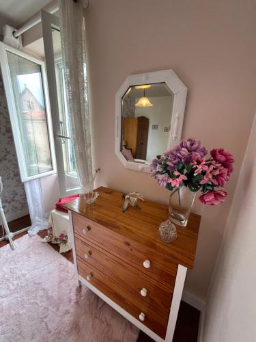a bathroom with a dresser with a mirror and flowers on it at Sundown in Paillé
