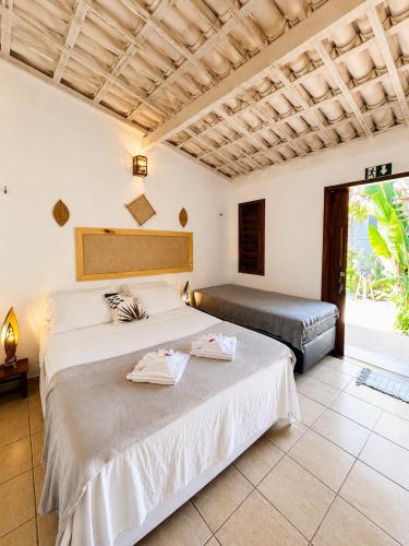 a bedroom with two beds and a window at Pousada Tangerina in Icaraí