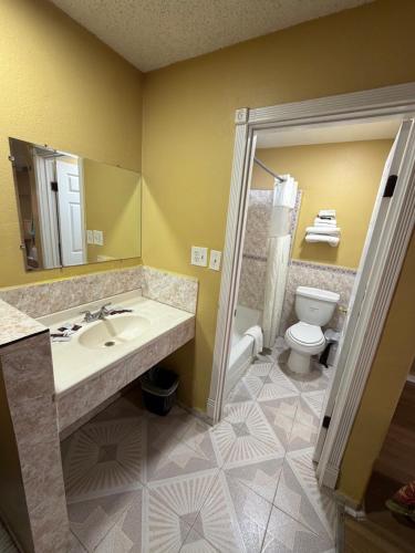 a bathroom with a sink and a toilet at Penguin Motel in Harbor City