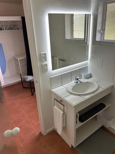 a bathroom with a sink and a mirror at Central Motel in Rarotonga
