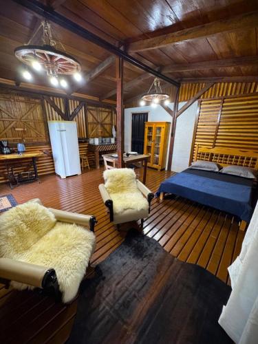 a bedroom with a bed and two chairs and a table at Ruhehaus in Arabutã