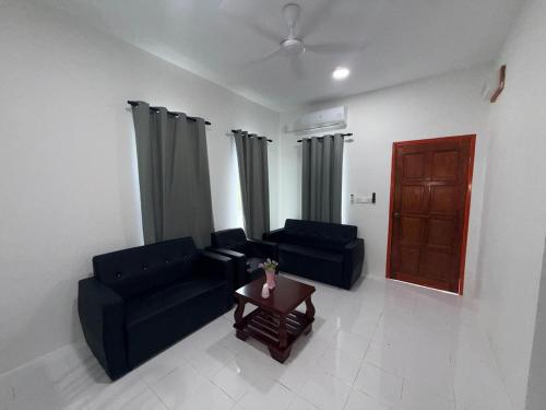 a living room with two blue couches and a table at AiNi's Homestay 2 in Sipitang