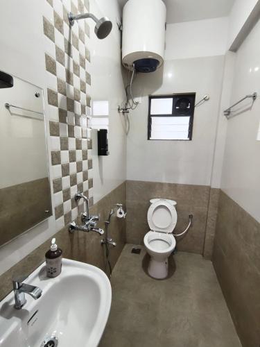 a bathroom with a white toilet and a sink at Casa Santana in Dabolim
