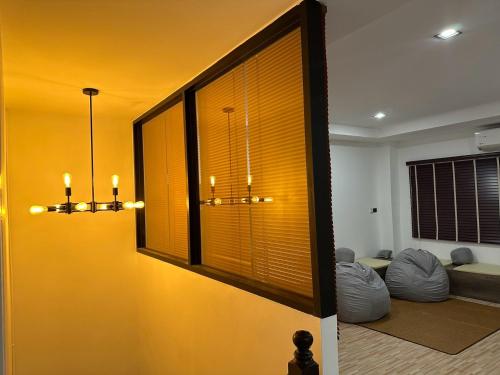 a living room with yellow walls and a large window at 9 mins to BTS Queen Private Room Share Bath in Amphoe Phra Khanong