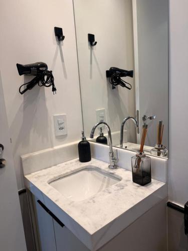 a bathroom counter with a sink and a mirror at Loft Elegante proximo do Shopping Esmeralda in Marília