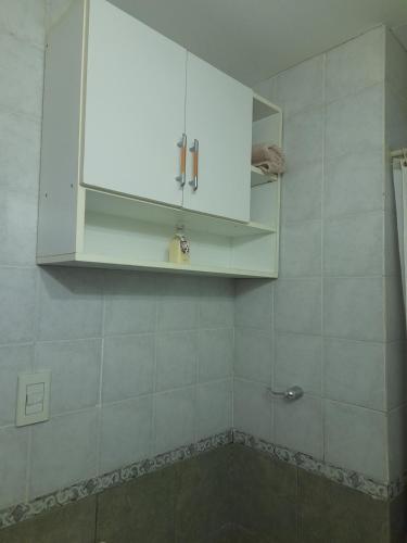 a kitchen with white cabinets and a tiled wall at Neyen in La Plata