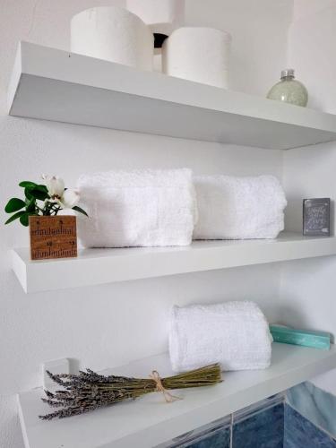 a shelf with towels and a vase of flowers on it at Dhimarko Guest House in Përmet