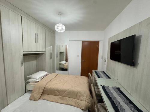 a bedroom with a bed and a flat screen tv at Studio Brooklyn - 3 minutos da EPCAR in Barbacena