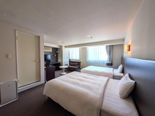 a hotel room with two beds and a large window at Green Rich Hotel Kagoshima Tenmonkan in Kagoshima