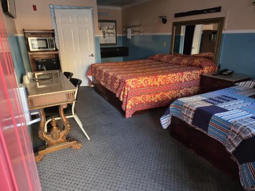 a hotel room with two beds and a mirror at Evans Motel in Maywood