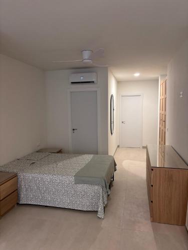 a bedroom with a bed and a dresser and a door at APARTAMENTO LEPANTO in Almazora