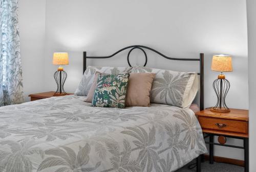 a bedroom with a bed with two lamps on tables at Cockles on Willmett road in Goolwa