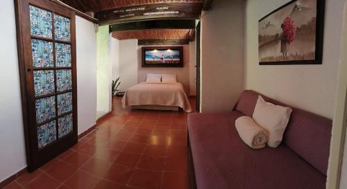 a bedroom with a bed and a couch in a room at Casa Pahpaqui in Tequisquiapan