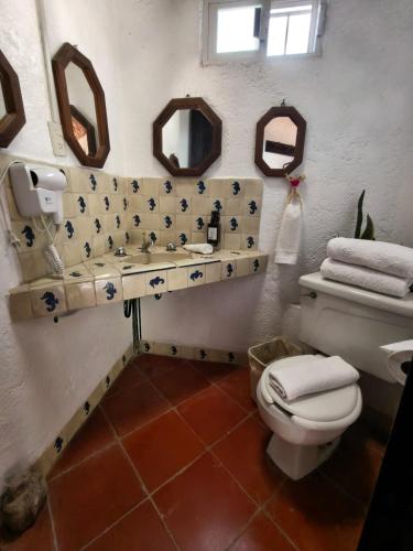 a bathroom with a toilet and a sink and mirrors at Casa Pahpaqui in Tequisquiapan