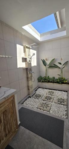 a bathroom with a shower with plants in it at Villa Segara Agung Amed in Amed