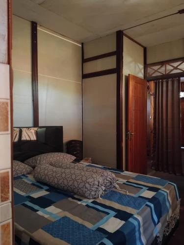 a bedroom with a bed with a quilt on it at STELAMARIS HomeStay in Pulau Bunaken