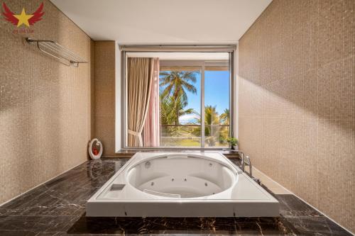 a large bath tub in a bathroom with a window at The Five Stars Villa 6 Bedrooms Beachfront in Danang