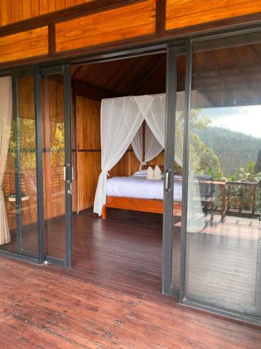 a bedroom with a bed inside of a house at Puri Sunset Homestay in Munduk