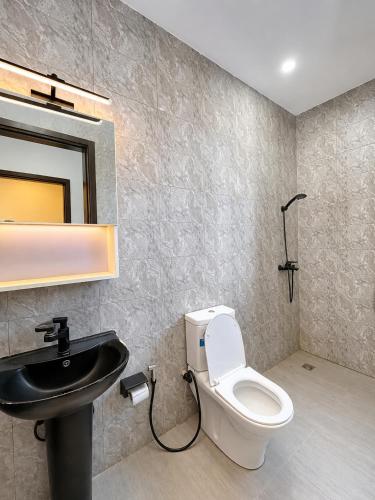 a bathroom with a toilet and a sink at EDEN PALACE KIGALI AIRPORT AND APARTMENTs in Kigali