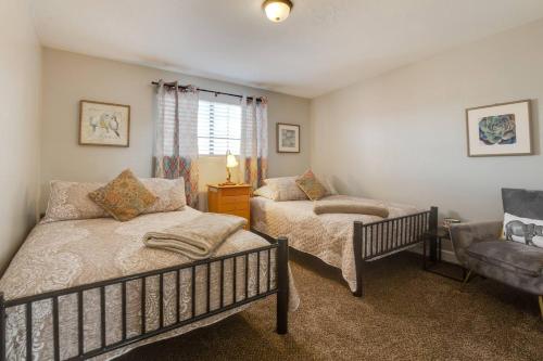 a bedroom with two beds and a couch and a chair at Fly Away Home in West Jordan
