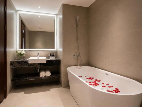 a bathroom with a white tub and a sink at La Passion Elegance Hotel & Spa in Hanoi