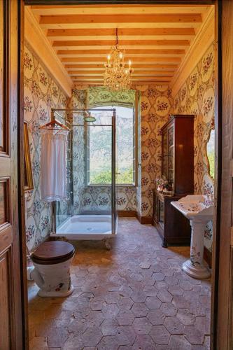 a bathroom with a tub and a toilet and a sink at Chateau de Gudanes in Château-Verdun