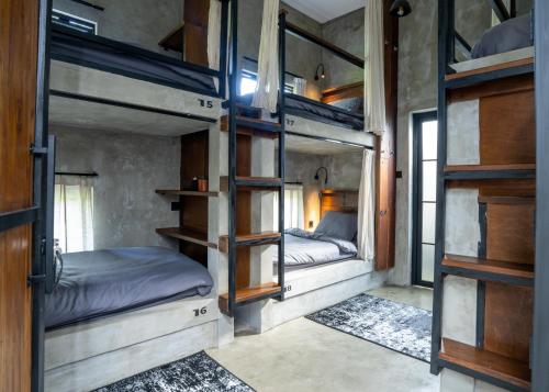 a room with three bunk beds in a house at Iron Wave Uluwatu in Bingin Beach