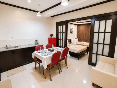 a dining room with a table and red chairs at Amax Inn Makati in Manila