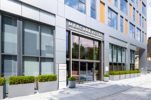 an office building with a sign for the mercure hotel at Mercure Ambassador Seoul Dongdaemun in Seoul