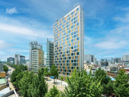 a tall building in the middle of a city at Mercure Ambassador Seoul Dongdaemun in Seoul