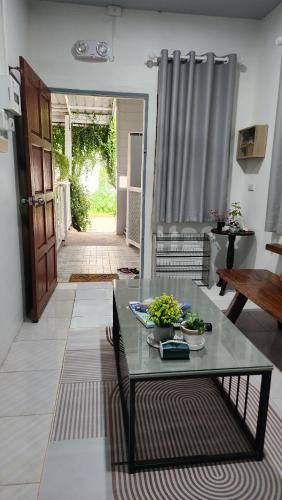 a living room with a glass table and a door at 338 Studio in Ban Liam