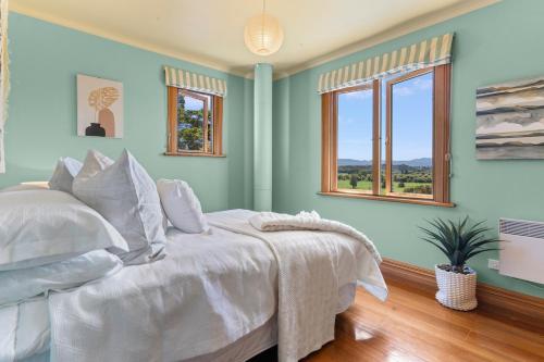 a bedroom with a white bed and two windows at Sheena Apartment in Manila