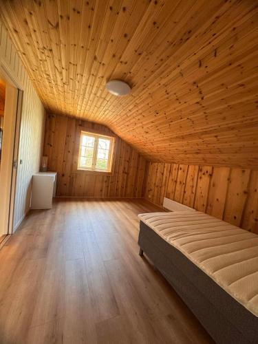 a bedroom with a bed in a wooden room at Grefstadvigveien 12 in Grimstad