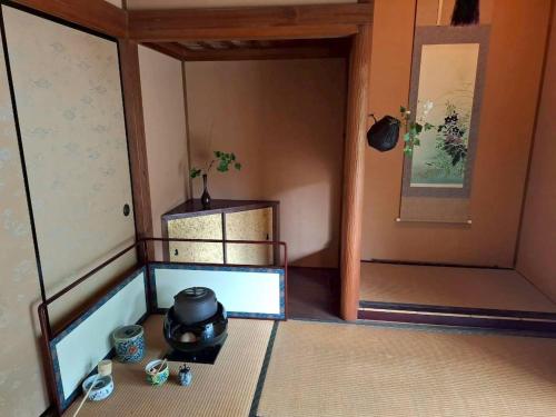 a small room with a stove and a door at 茶室山谷庵 in Gero