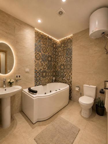 a bathroom with a tub and a toilet and a sink at Royal Aida Pyramids View INN in Cairo