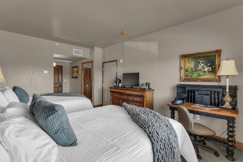 a bedroom with two beds and a desk with a computer at Zermatt Mountain Lodge Studio in Midway
