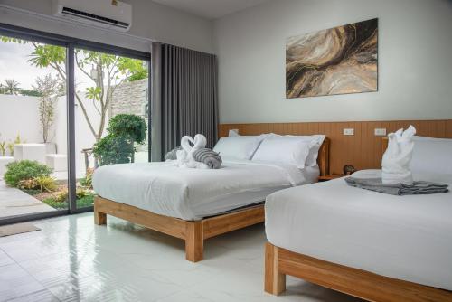 two beds with stuffed animals on them in a bedroom at Turtle Tales-Tao Kra in Thai Muang