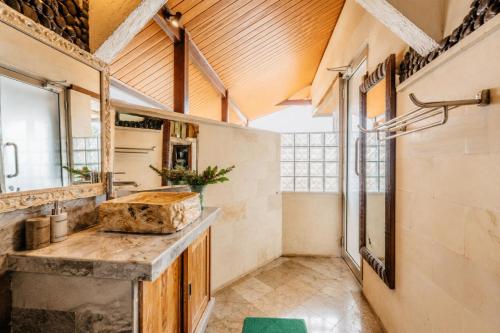 a large bathroom with a sink and a window at River Song Ubud, Bali in Ubud