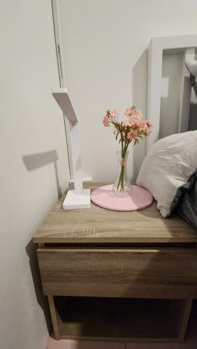a table with a lamp and a vase with flowers on it at 338 House in Ban Liam