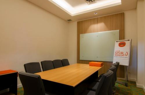 a conference room with a wooden table and chairs at HARRIS Hotel and Conventions Denpasar Bali in Denpasar