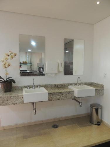 a bathroom with two sinks and a mirror at Hotel Luni in Sao Paulo