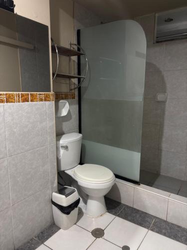 a bathroom with a white toilet and a shower at Hospedaje Lima Suite in Piura