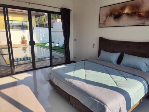 a bedroom with a bed and a large window at Nana's Bar & Hotel in Nong Prue
