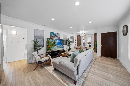 a living room with a couch and a tv at Entire Private House with King Bed, 80 TV, Gated Yard, Ranch Style, 4 Bedrooms 2 Bathrooms, Available Now in El Cajon