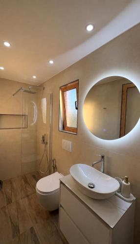 a bathroom with a sink and a toilet and a mirror at Castle View in Qeparo