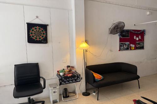 a room with a chair and a clock on the wall at Sleep Break Hostel Sathon in Bangkok
