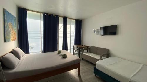a room with a bed and a couch and a window at Amazonas magic in Leticia