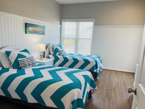 a bedroom with two beds and a window at Avalon East-Duplex in Holden Beach